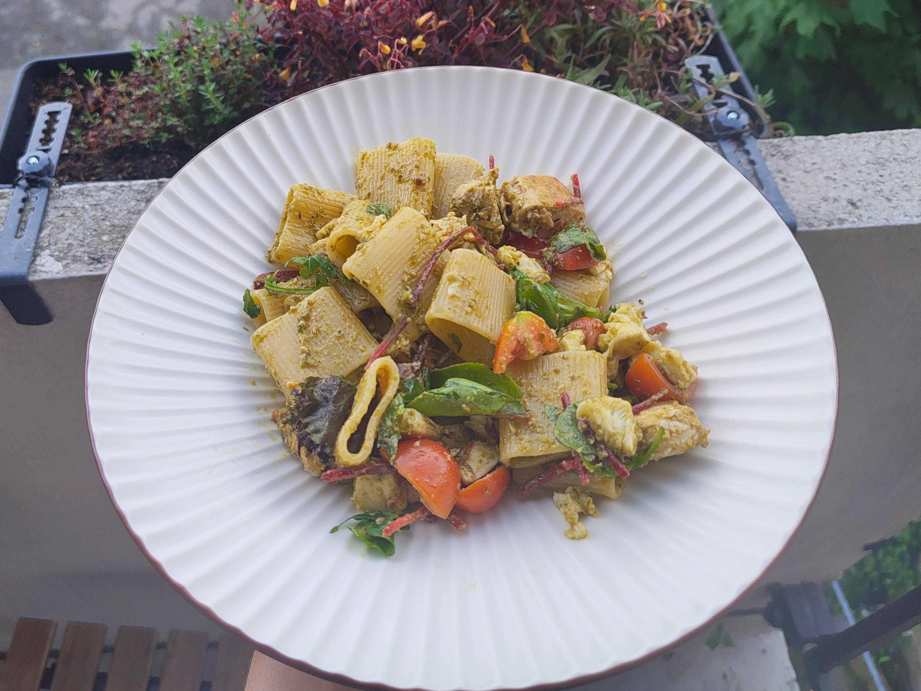 A bowl of pesto pasta with different ingredients