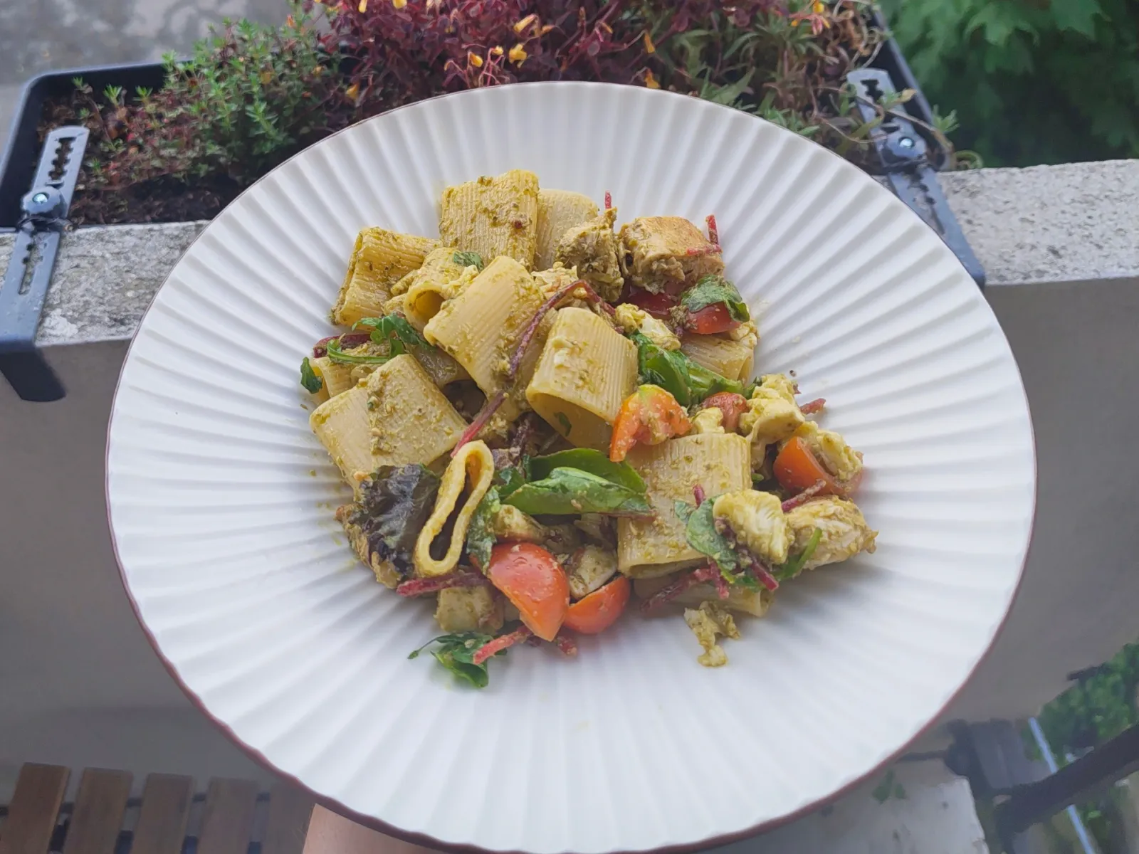 A bowl of pesto pasta with different ingredients